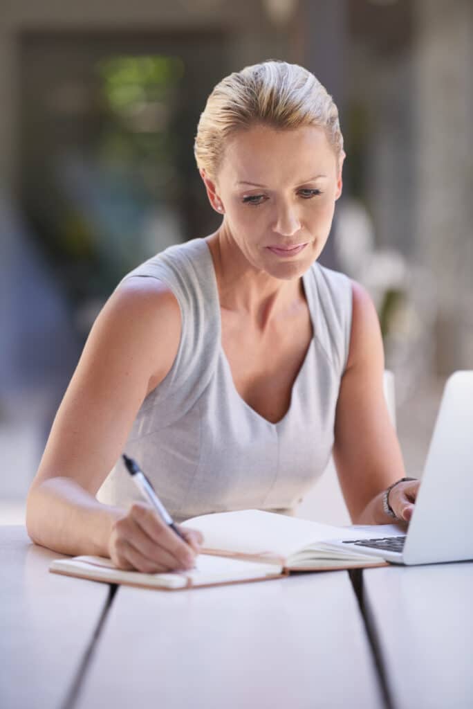 Personne en train d'écrire sur un journal pour un exercice de mémoire