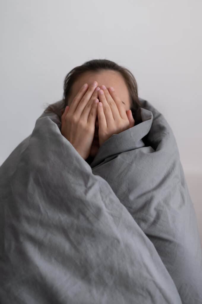 Personne enroulée dans ses draps en manque de sommeil