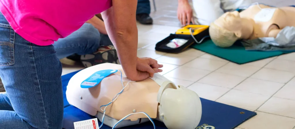 Personne qui pratique les gestes de réanimation sur un mannequin
